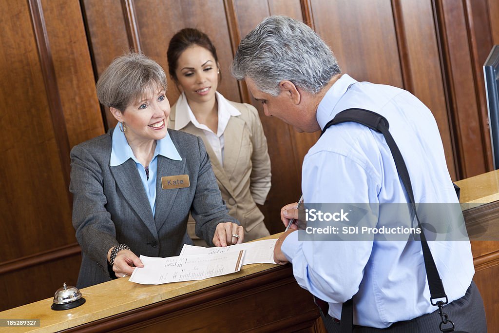 Réception Travailleur montrant la note d'hôtel du client - Photo de Adulte libre de droits