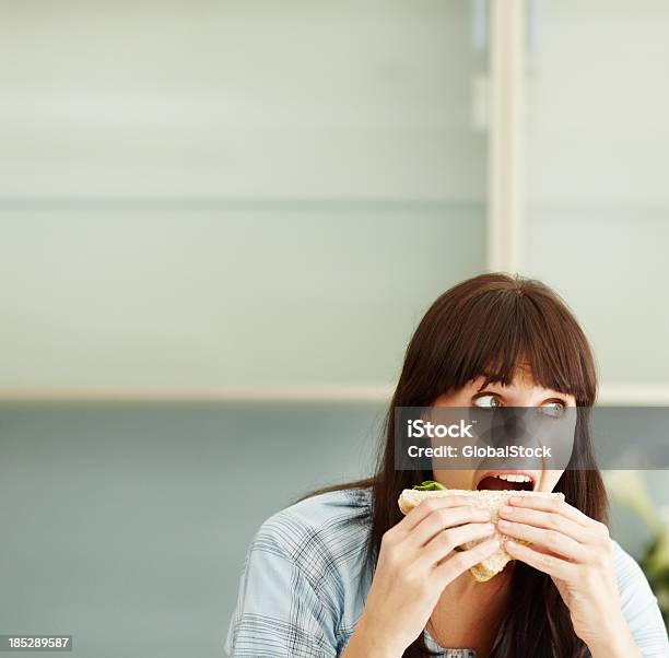 Girl Having Mouth Open Wide And Munching A Sandwich Stock Photo - Download Image Now