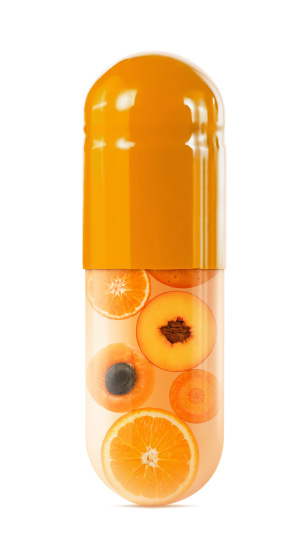 Orange fruits and vegetables in an orange capsule on white background. Clipping path included.