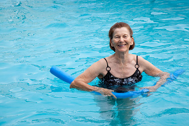 istock Active senior woman in swimming pool exercising with blue water 185290100