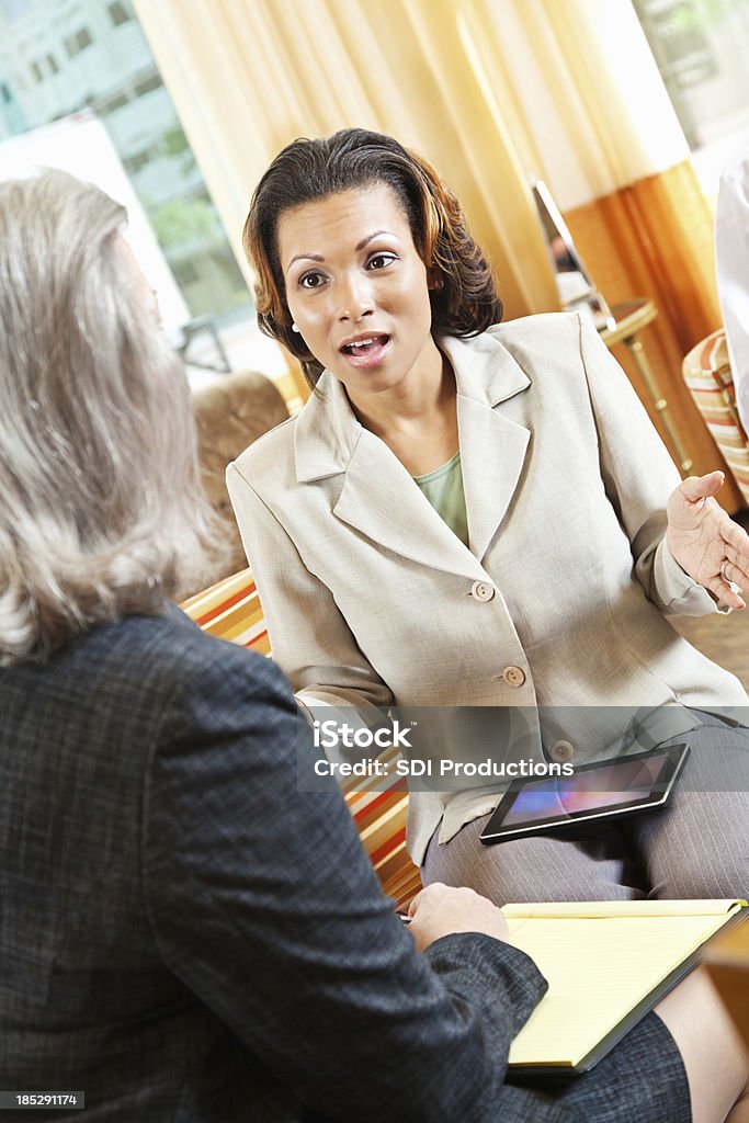 Geschäftsfrau erklären etwas zu den Kunden in der hotel lobby - Lizenzfrei Afrikanischer Abstammung Stock-Foto