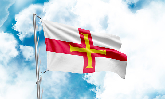 Guernsey flag waving on sky background. 3D Rendering