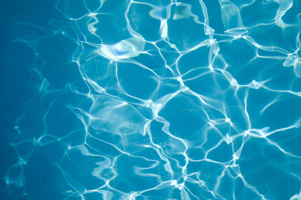 Overhead view of sun reflecting on blue water in a pool