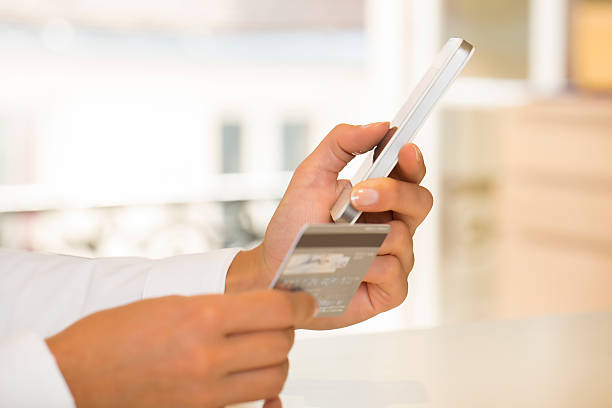 istock Woman's hands holding credit card and using cell phone 185293124