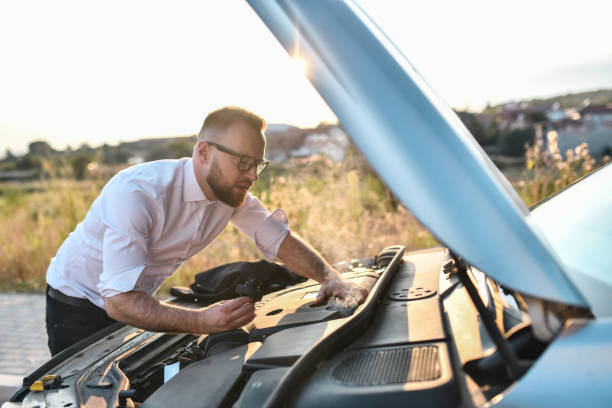 istock Businessman Checking Overheated Car Engine On The Road 1852945947