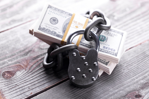 Money locked up in chain with lock. Concept for Secure investing. Savings. Retirement.
