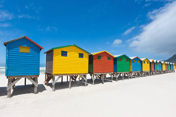 Muizenberg Beach Huts South Africa "Colorful beach huts in a row on the white sandy Beach of Muizenberg under a blue summer sky. Muizenberg, Cape Town, South Africa." stilt house stock pictures, royalty-free photos & images