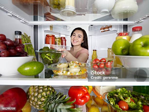 Foto de Mulher Tirando Brócolis Com Geladeira e mais fotos de stock de Geladeira - Geladeira, Cheio, Abrindo