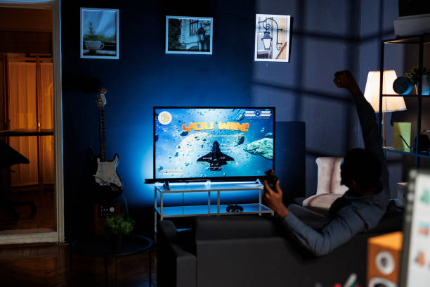 istock Enthusiastic player having fun winning shooting tournament on tv 1852958435