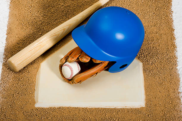 istock Batting helmet, glove, baseball and bat on home plate 185296025