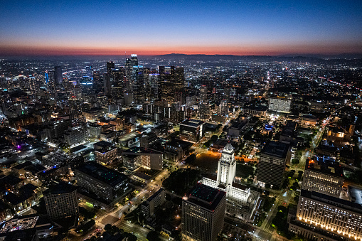 Magical moments of LA Downtown just after sunset during blue hour, captured from a helicopter point of view with lightened City Hall building.