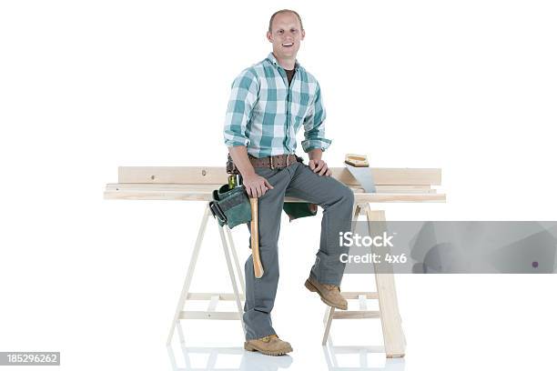 Carpinteiro Sittiing Sobre Um Cavalete De Serrador - Fotografias de stock e mais imagens de Sentar-se - Sentar-se, Empreiteiro de Reparações, Visão Frontal