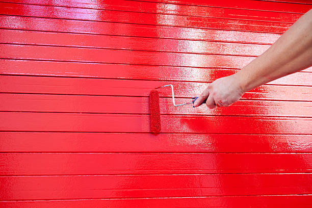 czerwony farba: ręka trzymająca wałek - wet paint zdjęcia i obrazy z banku zdjęć
