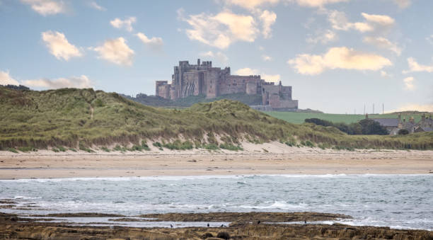 View of majestic crag top Bamburgh castle across the water from Seahouses, in Northumberland, UK View of majestic crag top Bamburgh castle across the water from Seahouses, in Northumberland, UK on 22 September 2023 Bamburgh stock pictures, royalty-free photos & images