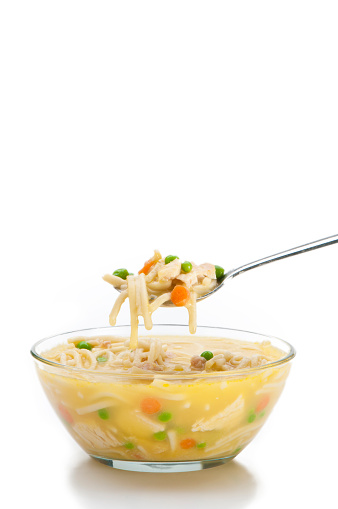 A bowl of cicken noodle soup on a 255 white background.