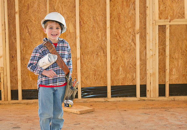istock Boy With Tool Belt & Hardhat Standing In New Home Construction 185296678