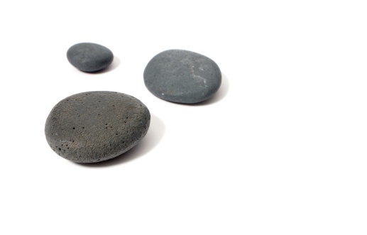 The photo shows three grey stones isolated on white.