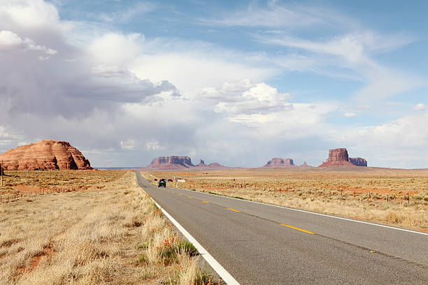 istock straight road to Monument valley under cloudy sky 185297356