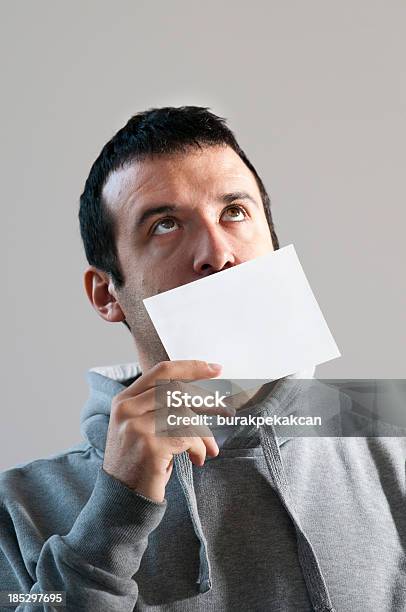 Hombre Sosteniendo Una Tarjeta En Blanco En Frente De La Cara Foto de stock y más banco de imágenes de Cara humana