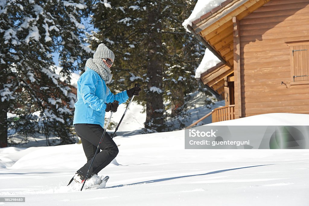 Con le racchette da neve donna in un paese delle meraviglie dell'inverno - Foto stock royalty-free di 30-34 anni