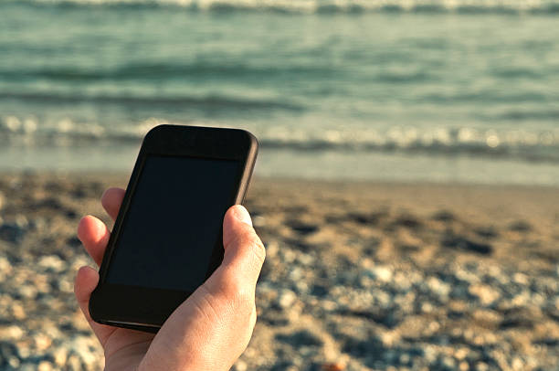 Woman sitting when talking to the mobile phone by the beach