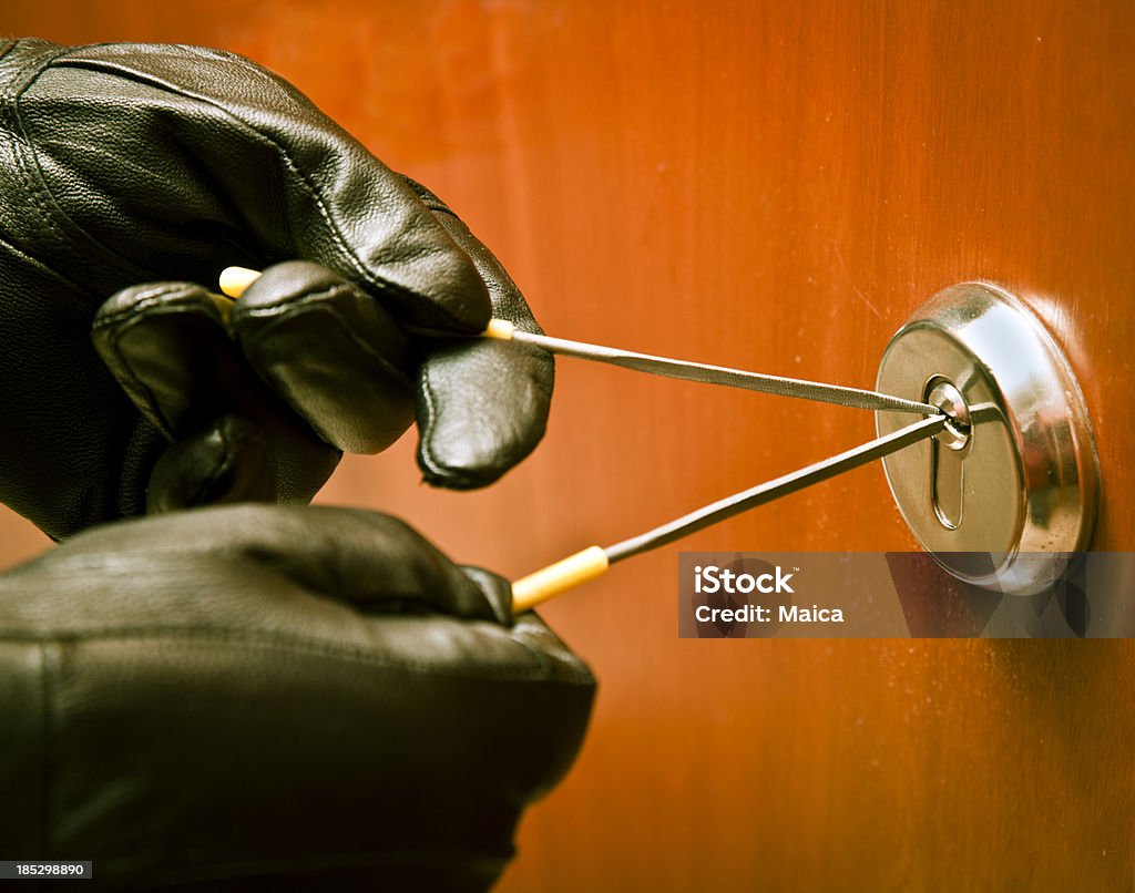 Thief opening a lock with picklock Hands of a thief using a picklock. Burglar Stock Photo