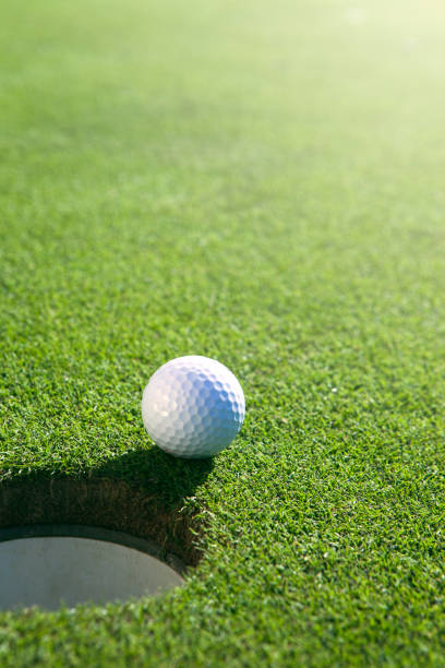 Golfball close to hole stock photo