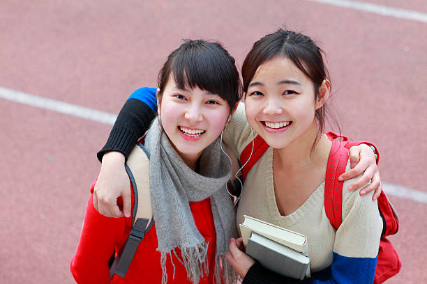 istock two lovely college students looking at camera smile 185299226