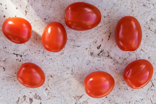 Red fresh cherry tomatoes on the natural cork background.