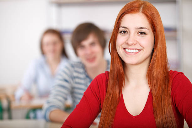 istock Female college student smiling in front of classroom 185299288
