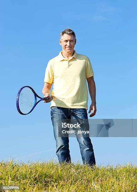 Photo libre de droit de Mature Homme Avec Une Raquette De Tennis banque d'images et plus d'images libres de droit de 50-54 ans - 50-54 ans, Adulte, Adulte d'âge mûr