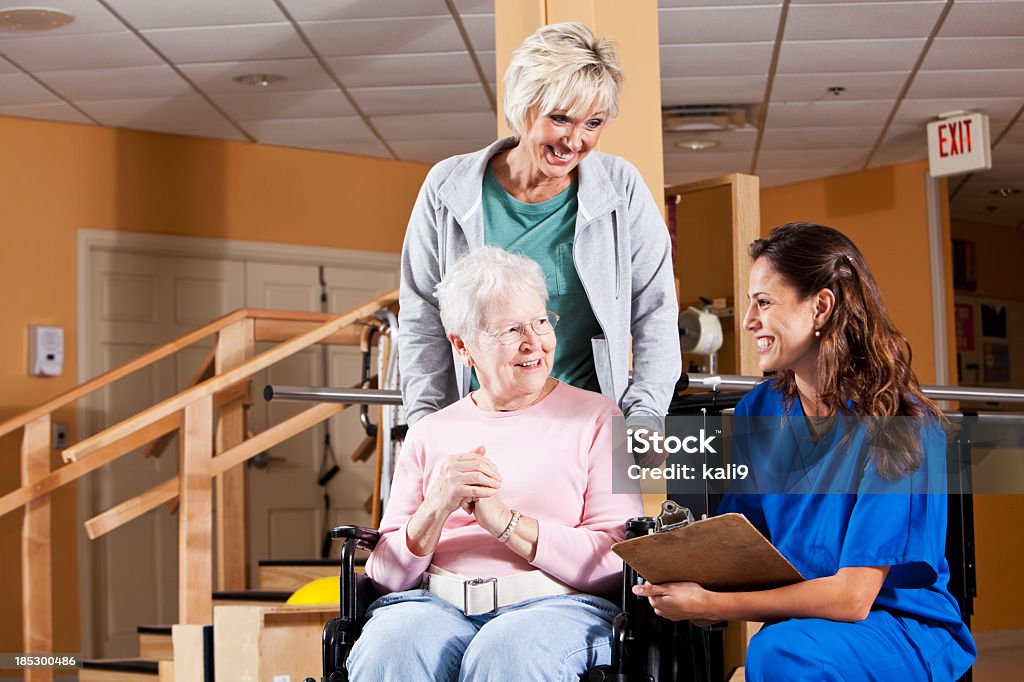 Mujer mayor y adultos hija hablando con fisioterapeuta - Foto de stock de Familia libre de derechos