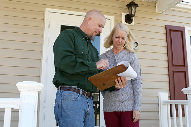 A woman talking to a home inspector on her front porch stock photo