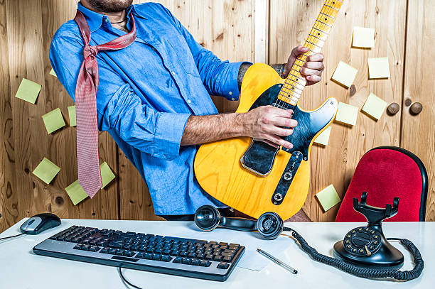 Office Worker Playing Electric Guitar On The Desk Office worker playing electric guitar on the desk. office fun business adhesive note stock pictures, royalty-free photos & images