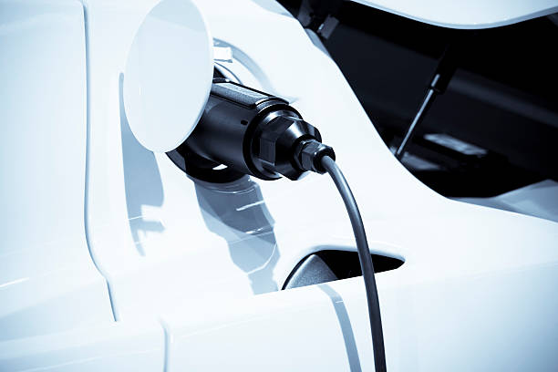Electric vehicle charging at pump Electric vehicle charging battery charger photos stock pictures, royalty-free photos & images