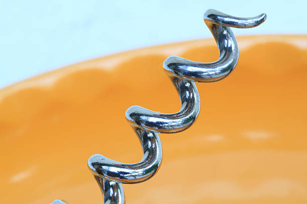 Top view of a vintage corkscrew shot on white background. The wine corkscrew is at the right of an horizontal frame leaving a useful copy space for text and/or logo. High key DSRL studio photo taken with Canon EOS 5D Mk II and Canon EF 100mm f/2.8L Macro IS USM.