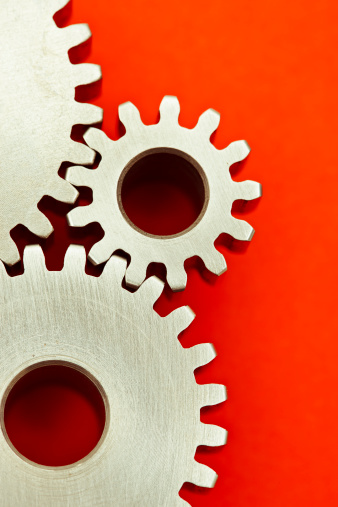 Detail of three meshing gears on red background
