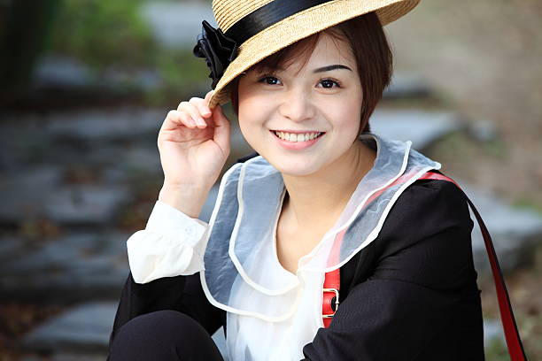 Portrait of attractive Japanese woman looking to camera. Beautiful Asian woman wearing stylish hat.