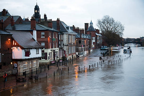 Floods "River in flood breaks its banks, covers the road and pavement, and floods the basement of the local pub. This is the River Ouse in the historic centre of York, UK." york yorkshire stock pictures, royalty-free photos & images