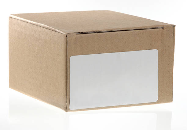 Small brown cardboard shipping box or carton with address label stock photo