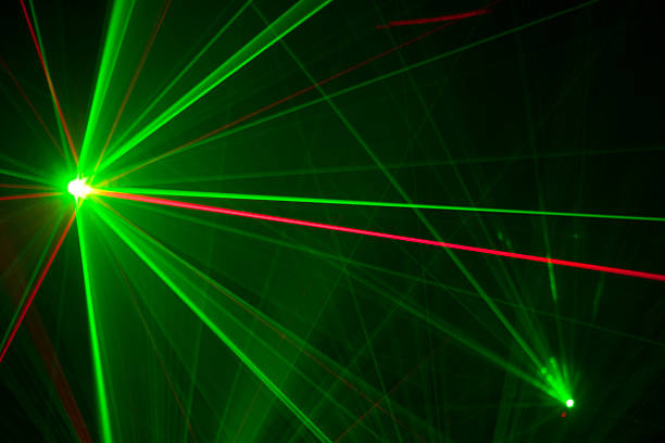 Green and red laser trails light up the darkness stock photo