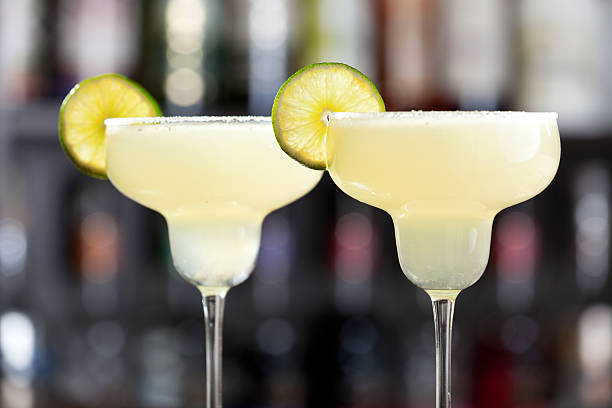 Two margaritas with lime wedges and salted glasses stock photo
