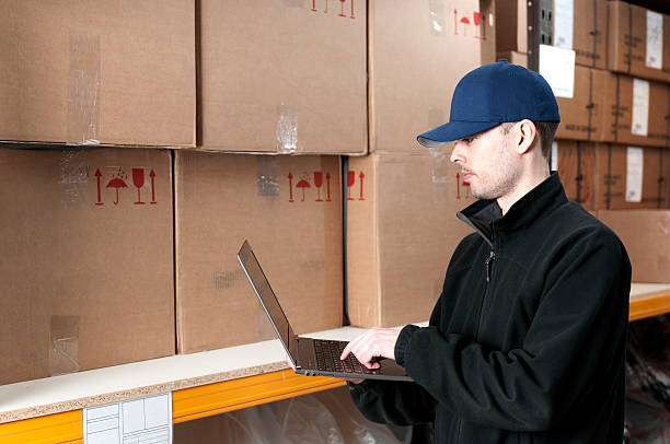istock Worker in storage room with laptop 185301926