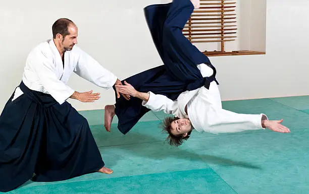 Two aikido masters demonstrating an aikido throw technique.