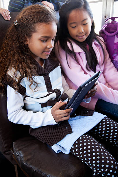 ragazze su scuolabus giocando con digital tablet - sc0536 foto e immagini stock