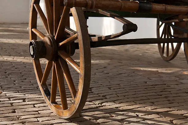 "Detail of an old wheel of a carriage. A carriage is a wheeled vehicle for people, usually horse-drawn."