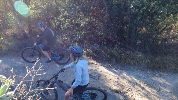 istock Friends ride mountain bikes on rural road 1853030087