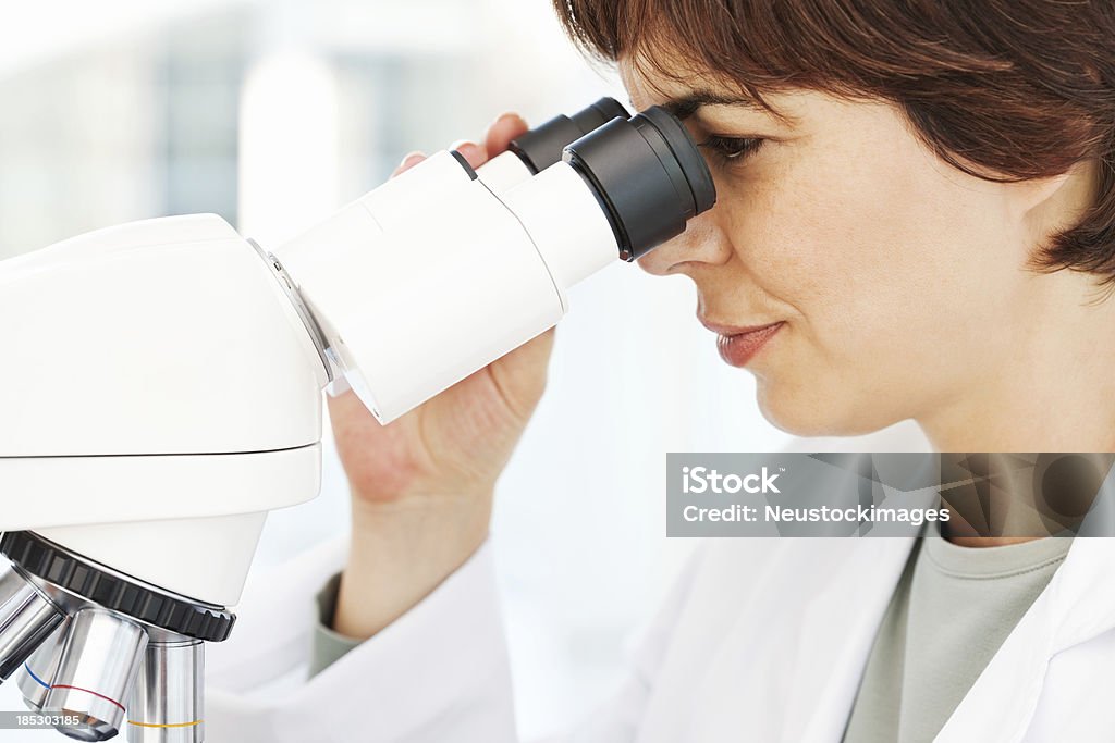 Patolog praca w laboratorium z mikroskopem - Zbiór zdjęć royalty-free (30-39 lat)