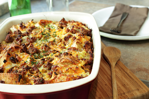 A bread pudding casserole made from French baguette bread, sage breakfast sausage, onions and cheddar cheese