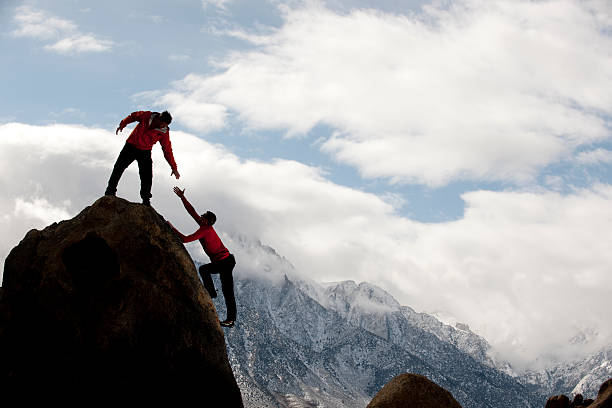 istock Man on top of mountain helping someone up 185305350
